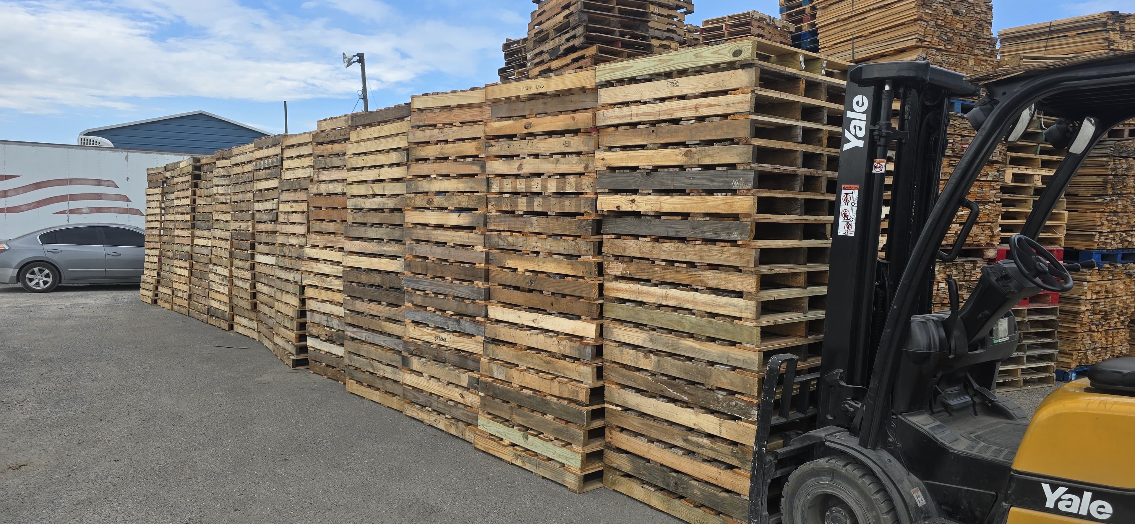 Pallets stacked with Yale forklift at outdoor facility
