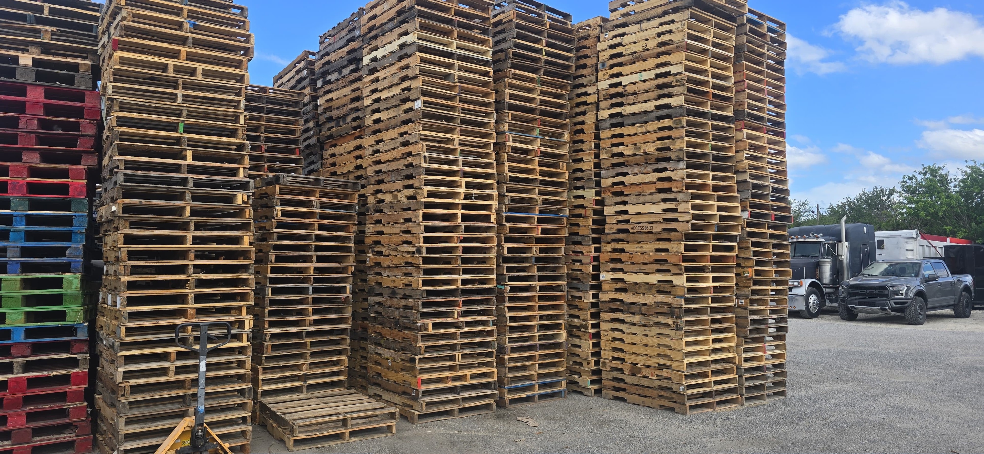 Mixed wooden pallets in large outdoor yard